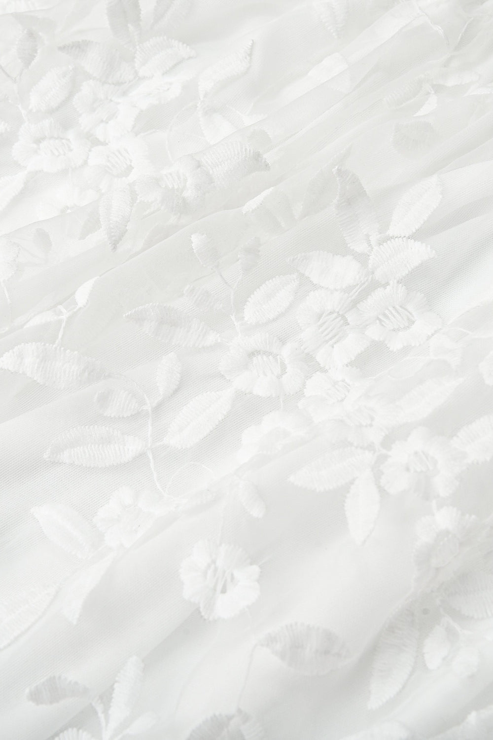 Rückansicht eines Damen Minikleids mit Trägern und zarter Blumenstickerei