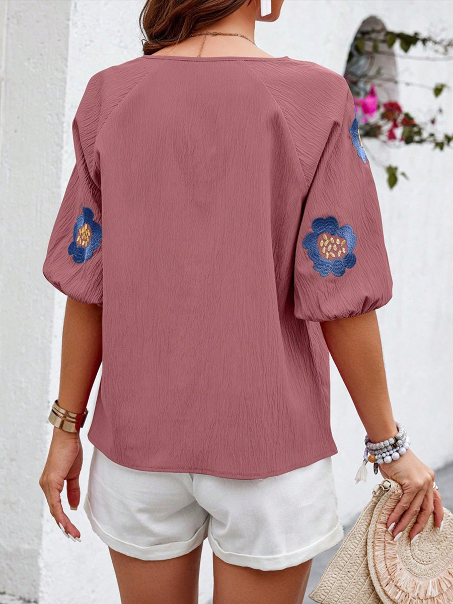 Detail des V-Ausschnitts mit Bindeband an der Bluse