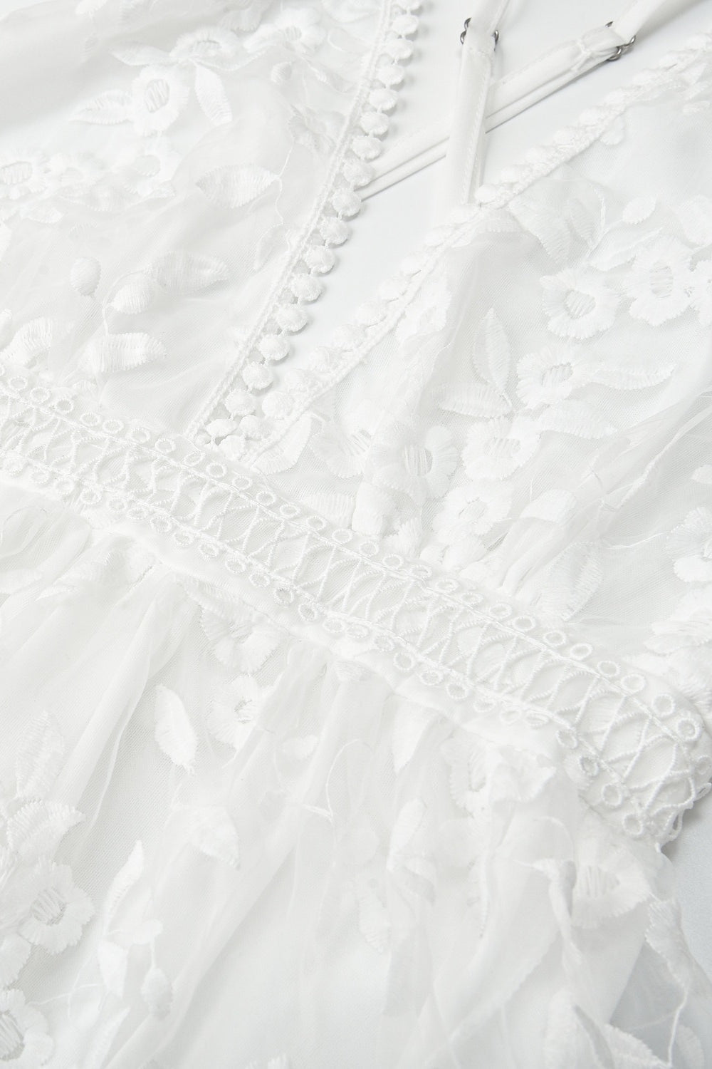 Detailaufnahme der floralen Stickerei und Spitzenstruktur am Damen Kleid