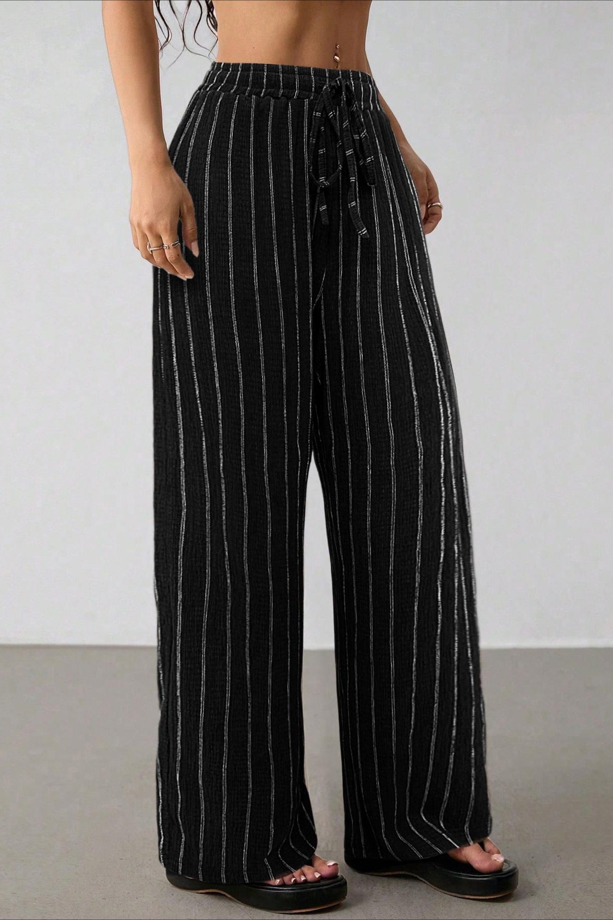 Detailansicht der Wide-Leg-Hose mit Streifenmuster und fliessendem Stoff